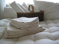 Organic Cotton sheets folded on bed with Pillows, Neck Rolls and comforter